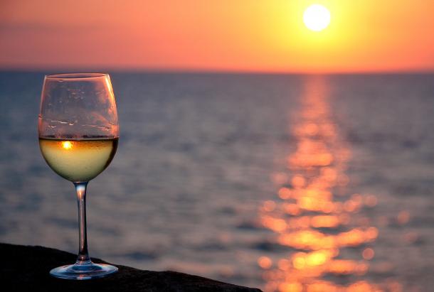 White wine glass over sunset in Apulia